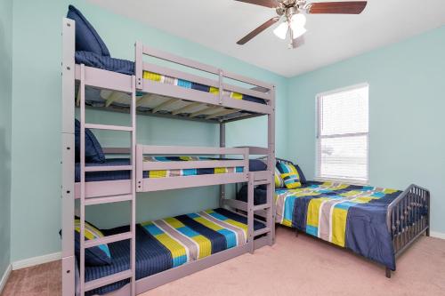a bedroom with two bunk beds and a ceiling fan at Summer Bliss,Blocks to the Beach-Midtown Galveston in Galveston