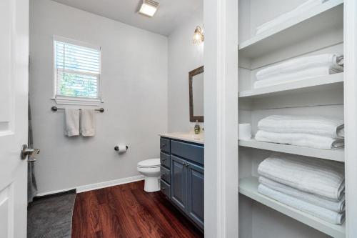 a bathroom with a toilet and a sink and a mirror at Summer Bliss,Blocks to the Beach-Midtown Galveston in Galveston