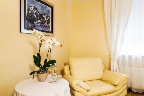 a living room with a yellow couch and a table with a chair at Hotel Komeda in Ostrów Wielkopolski