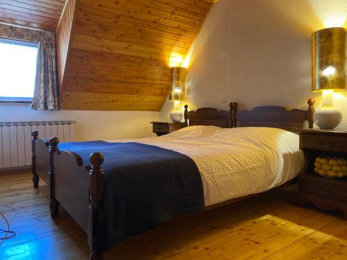 een slaapkamer met een groot bed en een houten plafond bij Luxurious Townhouse Petelin in Plužna
