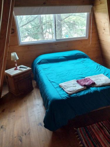 Habitación pequeña con cama y ventana en Cabaña alpina Las Lomas en Monte Hermoso
