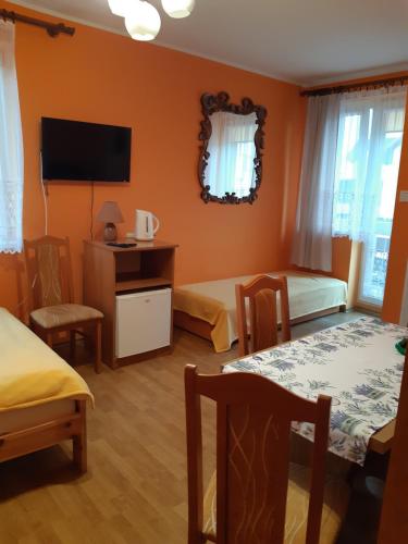 ein Hotelzimmer mit 2 Betten und einem Flachbild-TV in der Unterkunft Pokoje Magda in Władysławowo