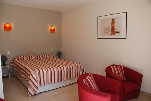 a bedroom with a bed and a red chair at Au Bon Penequet in Pujaut