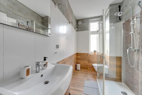 Un baño con lavabo blanco y ducha. en Skandynawski - 4 osobowy apartament przy Monte Cassino by Grand Apartments, en Sopot