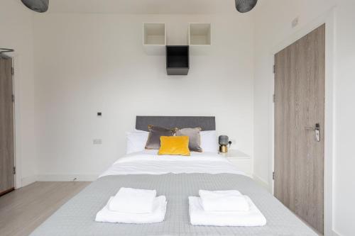 a bedroom with a bed with two towels on it at The Anson Hotel - Conveniently Located Sweet Space Near Transportation Stations in London