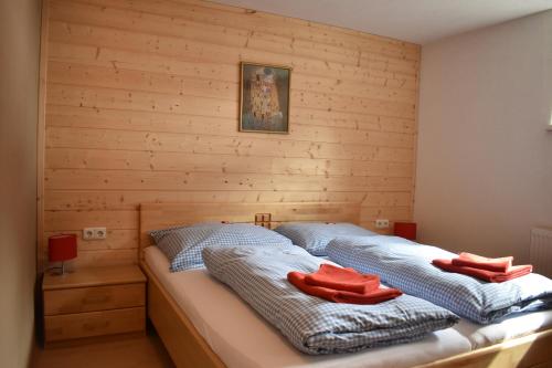 two beds in a room with wooden walls at Aparthotels Berwang / Haus Wiesengrund in Berwang