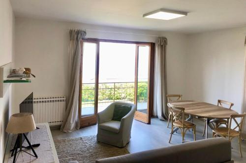 uma sala de estar com uma mesa e cadeiras e uma janela em Panoramic Apartment em Malcesine