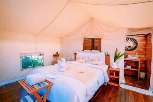 una camera con letto e TV in una tenda di Bali Cliff Glamping a Seraya