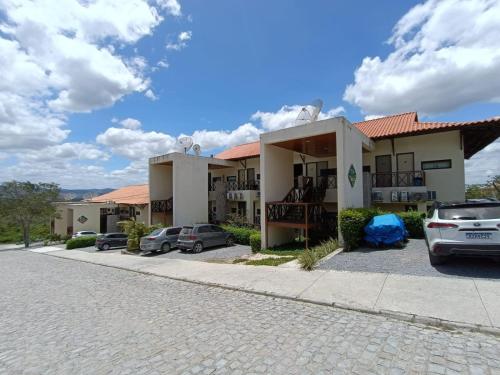 a building with cars parked in a parking lot at Flat Monte Castelo Gravatá in Gravatá