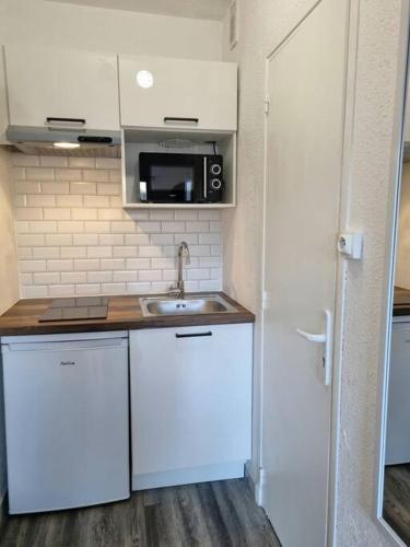 une petite cuisine avec un évier et un micro-ondes dans l'établissement Cap d'Agde - Studio - 2 pers - Sur le port, au Cap d'Agde