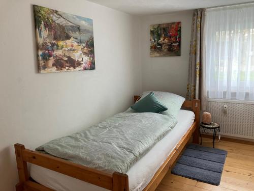 1 cama en un dormitorio con 2 cuadros en la pared en Ferienwohnung im Grünen mit Balkon en Herdecke