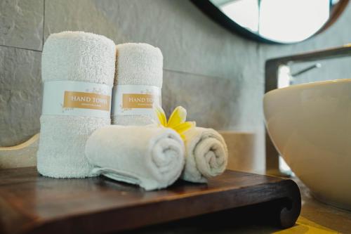uma pilha de toalhas numa mesa na casa de banho em Javana Royal Villas em Seminyak