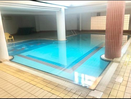 a large swimming pool with blue water in a building at proche kikar , piscine, spacieux et agréable in Netanya