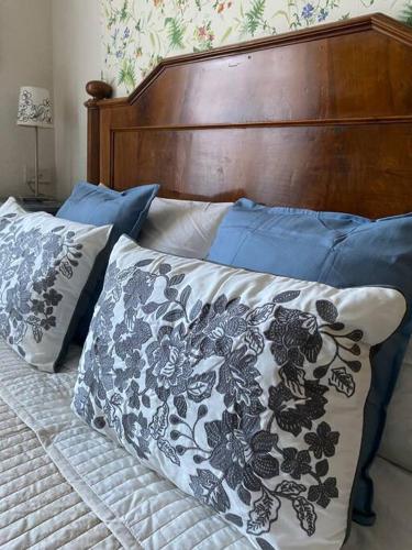 a bed with a wooden headboard and pillows on it at Casa Selli in Monte Compatri