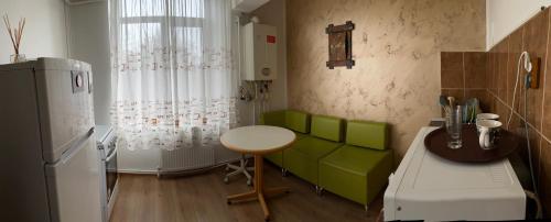 a kitchen with a green couch and a table at Garsoniera Centru in Galaţi