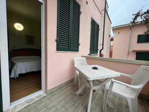 a table and chairs on a balcony with a bed at Hotel Villa Primavera in Pisa