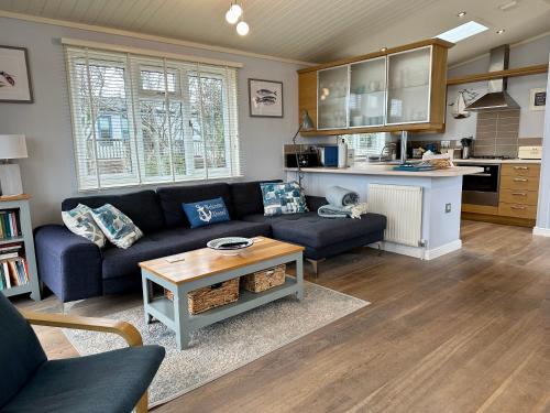 a living room with a couch and a table at Driftwood Lodge in Salcombe
