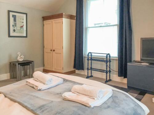 ein Zimmer mit einem großen Bett mit zwei Handtüchern darauf in der Unterkunft Upton Down in Keswick