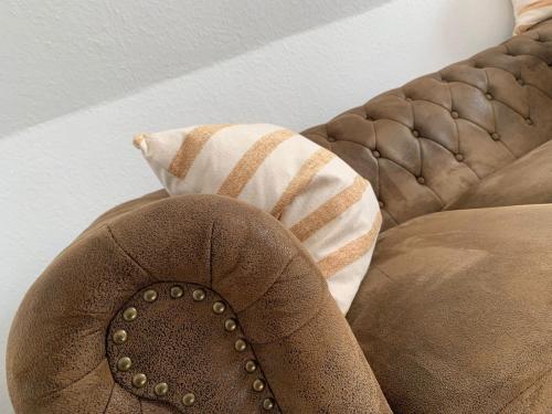 a brown couch with a pillow on top of it at Ferien- und Businessappartement am Lausitzring in Meuro