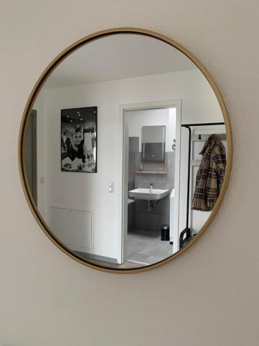 a mirror hanging on a wall with a bathroom at Ferien- und Businessappartement am Lausitzring in Meuro