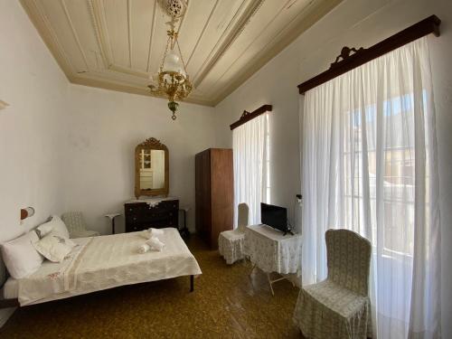 a bedroom with a bed and a chair and a mirror at Marthas Traditional House in Symi
