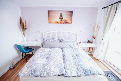 a white bedroom with a bed and a desk at Ferienwohnung Sunset bei Warnemünde in Rostock