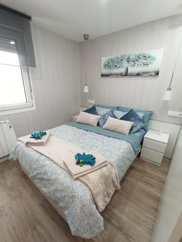 1 dormitorio con 2 camas y toallas. en Apartamento de Colón en Gijón