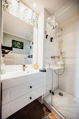 ein weißes Badezimmer mit Dusche und Waschbecken in der Unterkunft Ferienwohnung Sunset bei Warnemünde in Rostock