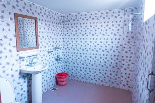 y baño con lavabo blanco y espejo. en Impulse Ocean View, en Cox's Bazar