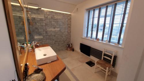 3 Bedroom Country Family Home near Masham في ماشام: حمام مع حوض ودش ونافذة