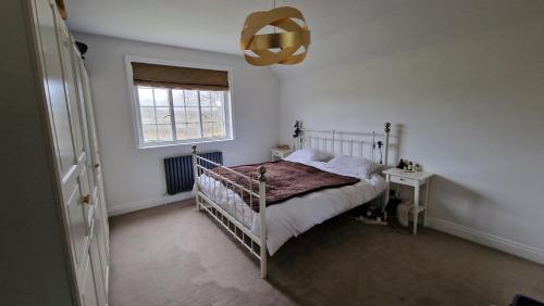 3 Bedroom Country Family Home near Masham في ماشام: غرفة نوم بها سرير ونافذة