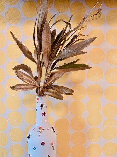 a white vase with a plant in it at Family Tree - WATER Available - SELF check in in Golem