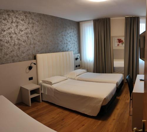a hotel room with two beds in a room at Parc Hotel in Poppi