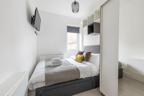 a bedroom with a bed and a mirror at Functional Double With An Ensuite Toilet And Shower Near Tube And Bus Stations in London