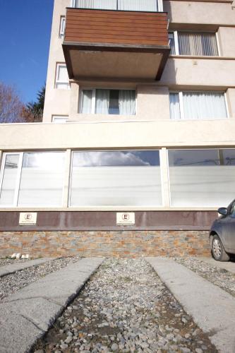 un edificio con ventanas y un coche aparcado delante de él en Akum en Ushuaia