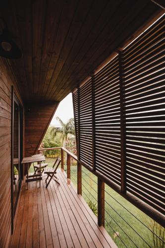 a wooden deck with a table and chairs on it at Pousada Colina Verde in Garopaba