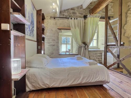 une chambre avec un grand lit dans une pièce dans l'établissement Chez Lydia - Loft cosy, départ canoë à pied, Proche Pont-du-Gard et Uzès, à Remoulins