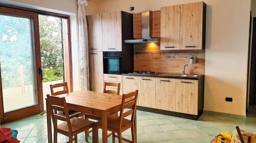 uma cozinha com uma mesa e cadeiras de madeira e uma cozinha com uma janela em La Casetta nel Bosco em Ischia