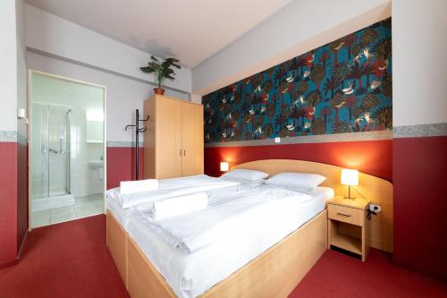 ブダペストにあるGartner Hotelのベッドルーム(大型ベッド1台付)、バスルームが備わります。