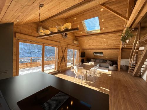 - une cuisine et un salon dans une cabane en rondins dans l'établissement Splendide appartement style chalet classé 4 étoiles, terrasse face à la montagne, à La Bresse