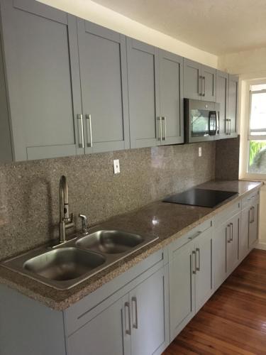 a kitchen with white cabinets and a sink at 1BR Historic Art Deco Charm Meets Modern Comfort- Huge Tropical Garden in Posh Coral Gables-10 min Airport in Miami