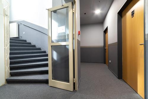 an open door in a hallway with stairs at Gartner Hotel in Budapest