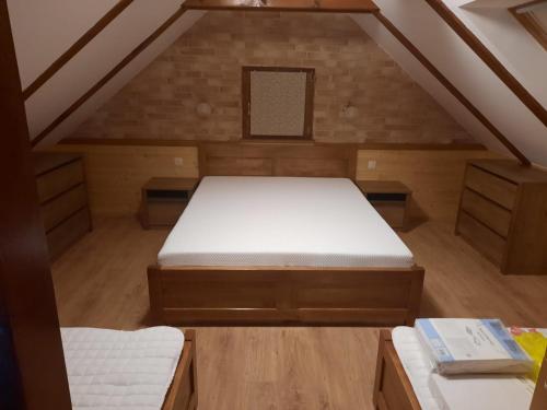 a attic room with a bed in the attic at Kuća sa bazenom za odmor i domjenke MARIS in Gornji Kraj