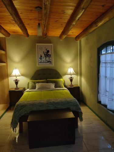 - une chambre avec un lit vert et 2 lampes dans l'établissement La Casona de Cerro Colonial, à Trapiche