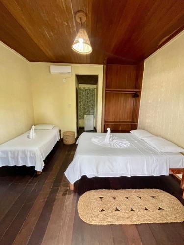 a room with two beds and a rug at Hotel Salinopolis e kitepoint in Salinópolis