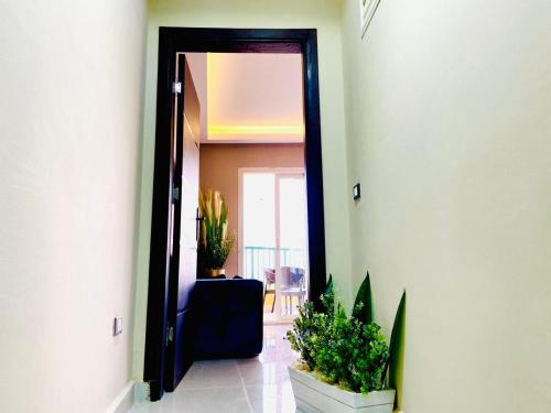 a hallway with a door open to a room with plants at Porto marina chalet and apartment in El Alamein