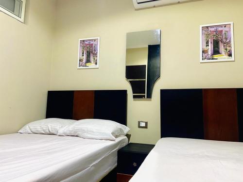 a bedroom with two beds and a mirror at Porto marina chalet and apartment in El Alamein