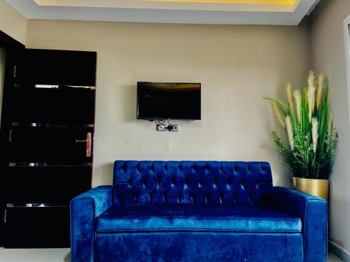 a blue couch in a living room with a tv at Porto marina chalet and apartment in El Alamein