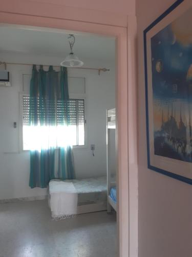 une porte menant à une chambre avec une fenêtre et un lit dans l'établissement Résidence meriem 2, à Hammamet