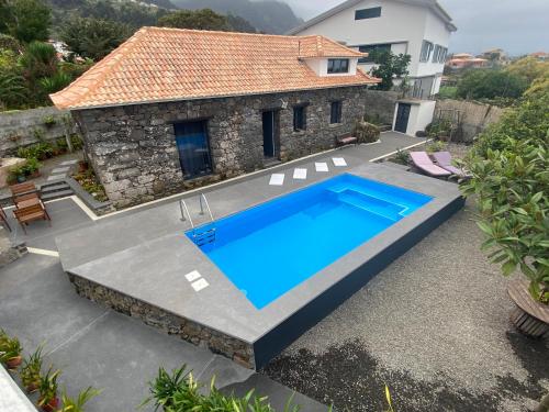 a swimming pool in front of a house at Cottage Quinze & Apartment with Swimming pool in Ponta Delgada